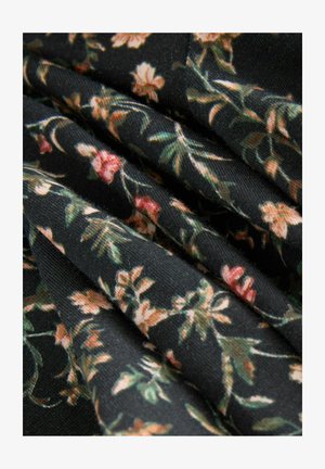 Tessuto floreale con sfondo nero, decorato con piccoli fiori rosa e crema e foglie verdi, che presenta un aspetto morbido e testurizzato.