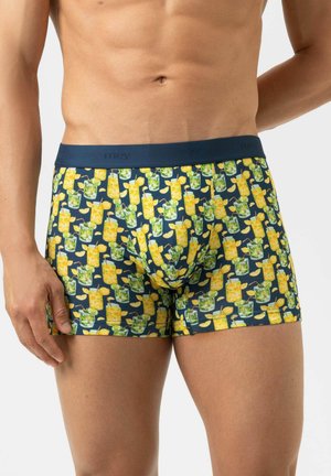 Männlicher Oberkörper trägt marineblaue Boxershorts mit einem Zitruscocktail-Muster, das Zitronenscheiben und Minzblätter zeigt.