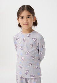 Szara koszula z długim rękawem z powtarzającym się wzorem jednorożców i gwiazd w pastelowych kolorach. Wykonana z miękkiego, lekkiego materiału.