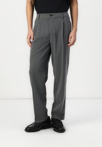 Pantaloni grigi a righe con una vestibilità rilassata, dotati di una piega frontale singola, chiusura con bottone e tasche laterali inclinate.