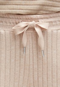 Weiches, rosa Freizeitoberteil mit horizontalen Streifen und passendem Unterteil mit vertikalen Streifen, elastischem Bund und einer Schleifendetail.