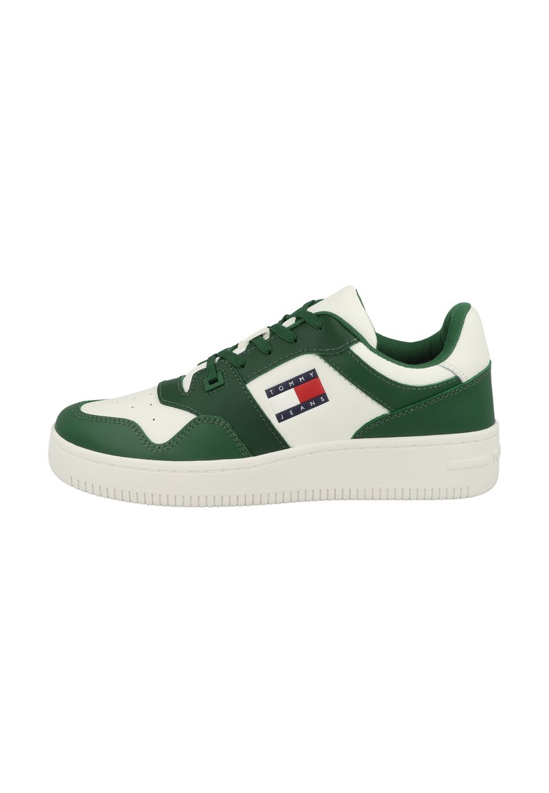Green and white sneaker with smooth synthetic material, featuring a logo patch, perforated toe, and rubber sole with horizontal ridges.