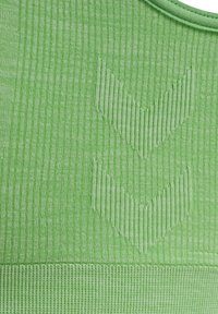 Grön sporttopp i texturerad tyg med vertikala ränder och två nedåtriktade pilar präglade på framsidan.