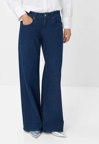 Wijde jeans in donkerdenim. Bevat een klassieke vijf-pocket ontwerp, knoopsluiting en een rechte snit tot aan de zoom.
