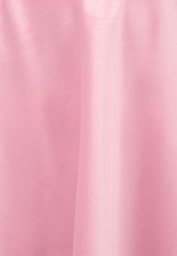 Μαλακό ροζ ύφασμα με απαλές πτυχώσεις και διακριτή υφή, δημιουργώντας μια ομαλή και κομψή εμφάνιση.