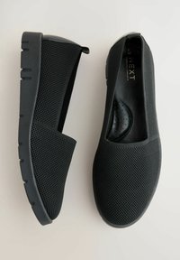 Czarne buty wsuwane z tkaniny o teksturowanej strukturze, grube gumowe podeszwy i wyściełane wkładki, zaprezentowane z widoków bocznego i górnego na jasnym tle.