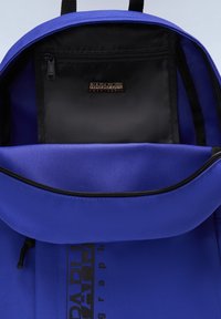 Blå ryggsäck med ett stort fack och en svart innerficka. Har blixtlås och en logotyp-patch. Strukturerad tyg med förstärkta remmar.