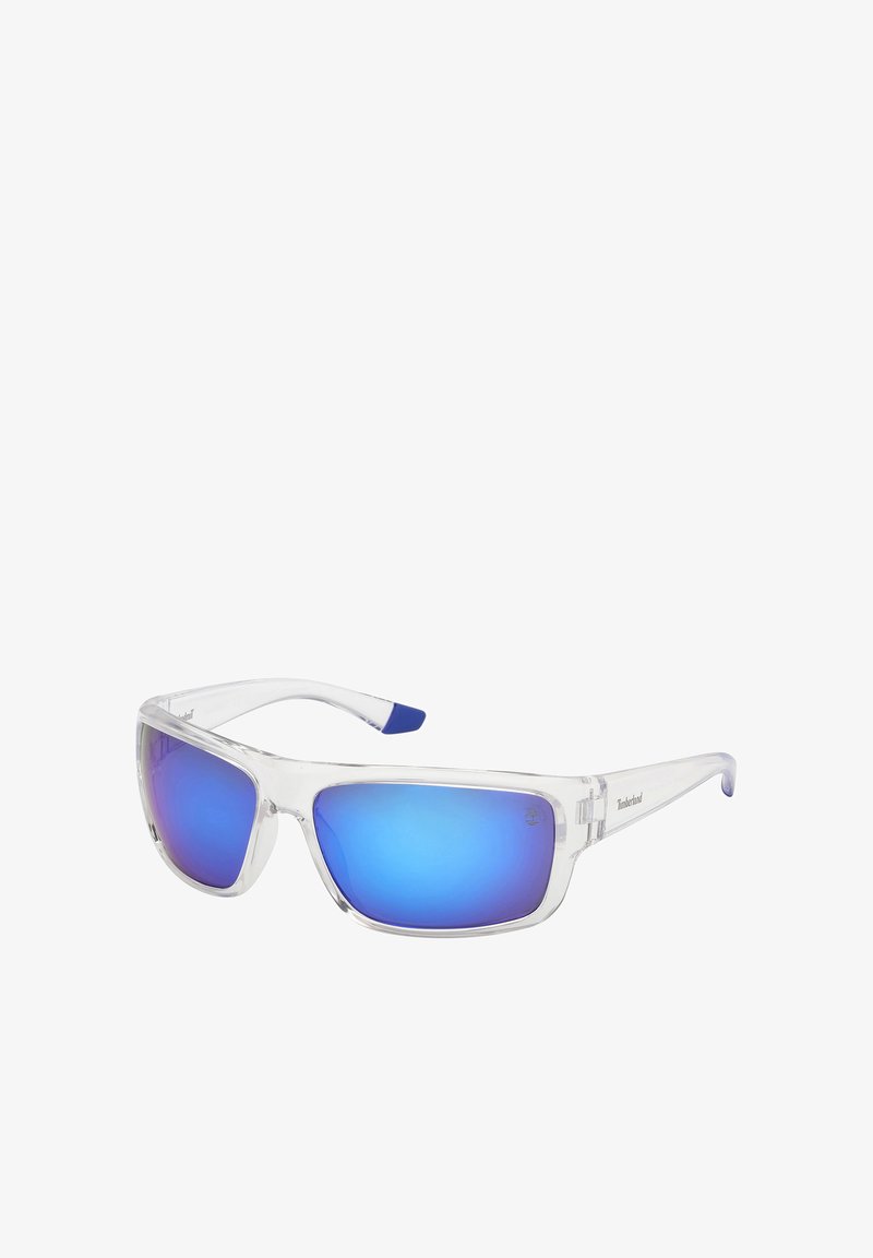 Lunettes de soleil avec monture en plastique transparent et verres rectangulaires bleus miroitants, logo Timberland sur la branche et le coin du verre.