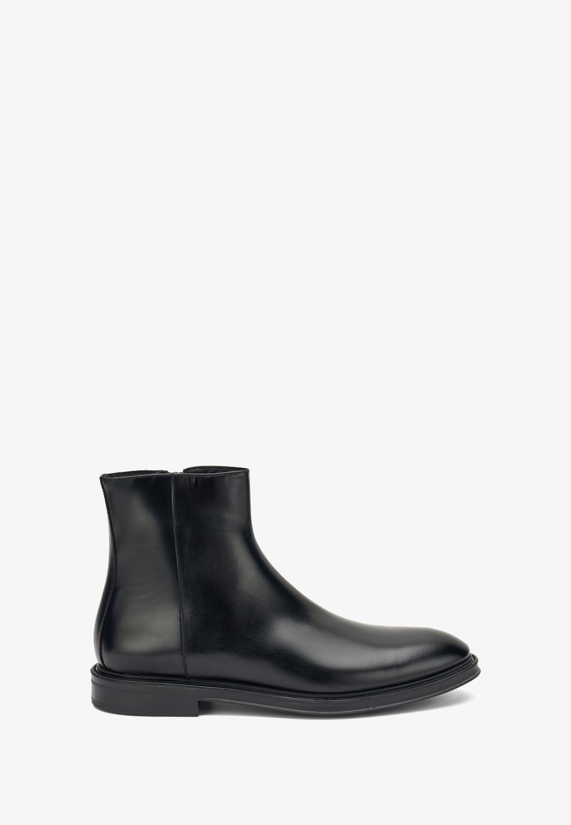 Botín de cuero negro hasta el tobillo con puntera redondeada, textura suave y tacón bajo apilado. Cuenta con un zipper lateral para facilitar el uso.