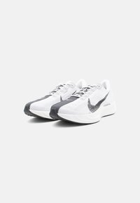 Zapatillas deportivas blancas con un upper de malla texturizada, que presenta acentos en gris oscuro y el logo de Nike. Suela blanca gruesa con un patrón de agarre.