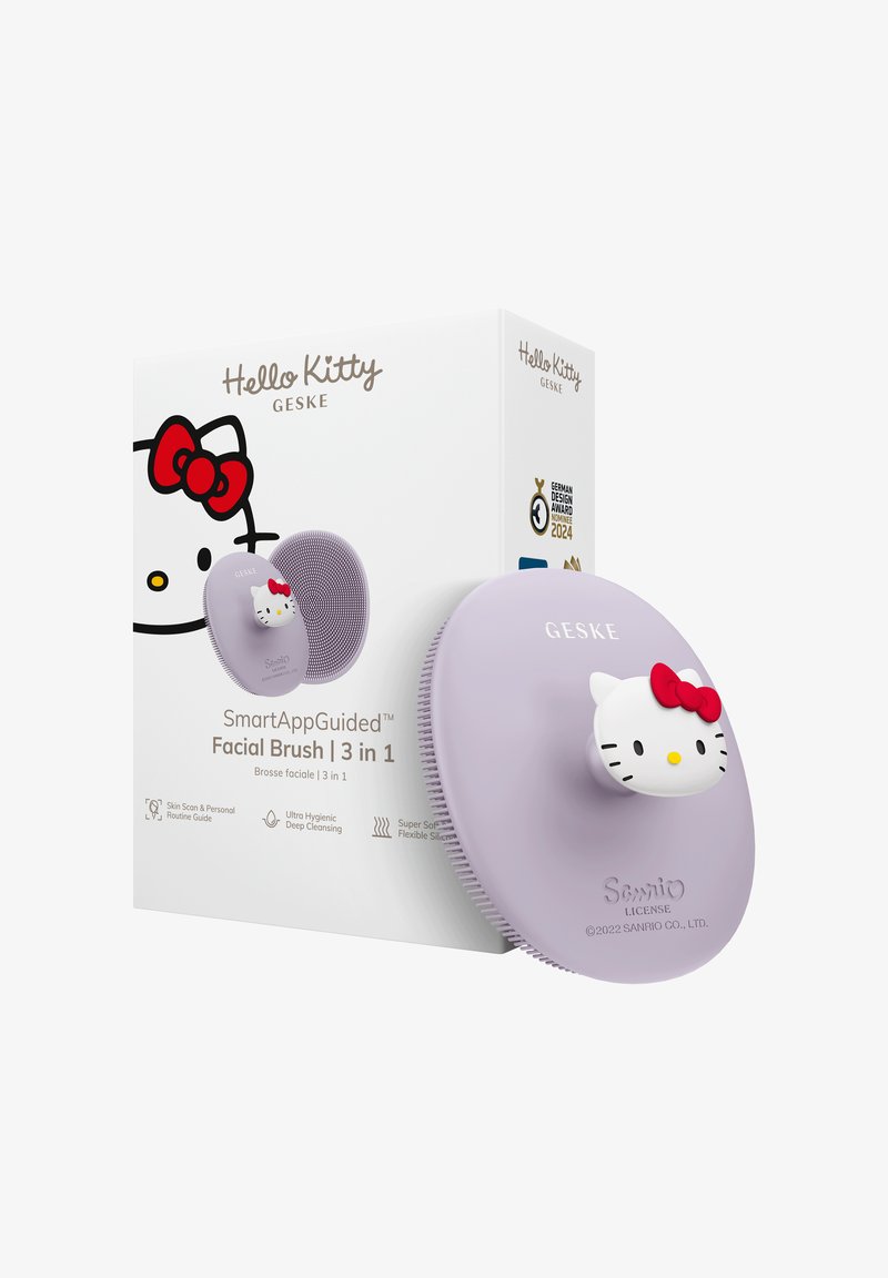 Lavender oval SmartAppGuided facial brush with Hello Kitty face handle next to white box featuring Hello Kitty design and product details.