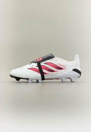 Biało-czerwony but piłkarski Adidas Predator z czarnym paskiem zakrywającym sznurowadła, umieszczony na neutralnym tle.