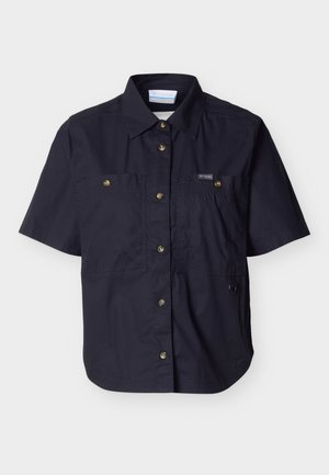 Zwart shirt met korte mouwen, knopen aan de voorkant, twee borstzakken met knopen en een klein logo op het linkerzakje.