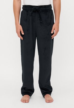 Black velvet lounge pants with elastic waistband and drawstring, featuring a relaxed fit and a soft texture. No visible patterns or accents.