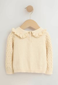 Cream knitted toddler sweater with cable-knit sleeves, ruffled collar, and two buttons on wooden hanger.