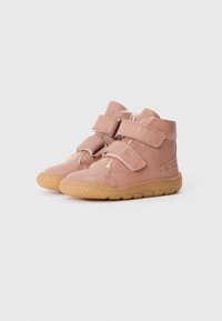 Botas de tobillo de cuero rosa con dos correas de Velcro, superficie texturizada y suela de goma flexible con patrones de agarre.