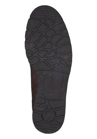 Semelle de chaussure en caoutchouc noir avec un motif de grip texturé, présentant des côtes et des formes hexagonales, marquée "Gabor" sur le côté.