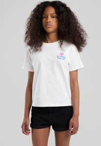 White cotton t-shirt with "SUMMER ESCAPE" text and shell graphic, paired with black denim shorts. Short sleeves and a relaxed fit.