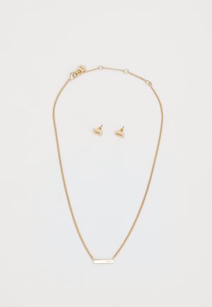 Collana di tonalità oro con una catena sottile e un ciondolo rettangolare. Orecchini a perno abbinati presentano piccole forme rettangolari con intagli decorativi.