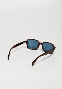 Ochelari de soare cu rame din material fărâmițat, dotati cu lentile albastre. Rame pătrate, brațe elegante și detalii aurii pe laterale, având o textură netedă.