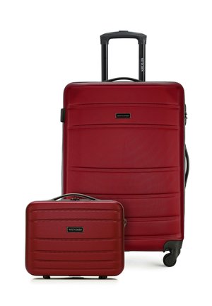 Maleta rígida roja con ruedas y asa telescópica, junto con bolsa de mano rígida roja a juego, ambas con líneas horizontales texturizadas.