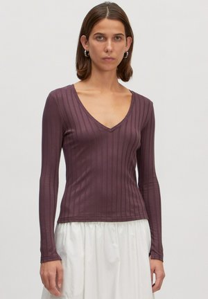 Langarm, diep V-hals top in donker mauve met verticale ribbelstructuur, getailleerde silhoutte en naaddetails aan de zoom.