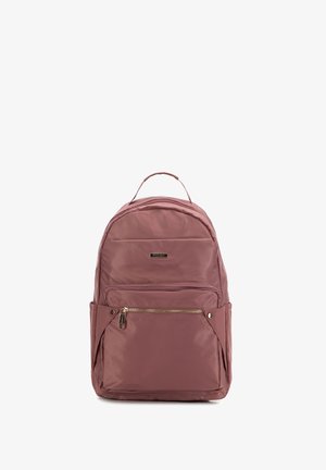 Mochila malva con asa superior, bolsillo delantero con cremallera, compartimentos laterales y logo metálico de la marca sobre tela lisa.