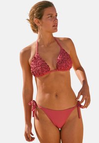 Koraalroze bikini met een textuur van bloemenontwerp op de bralette en een gladde effen stof op de zijbanden van de onderbroek.