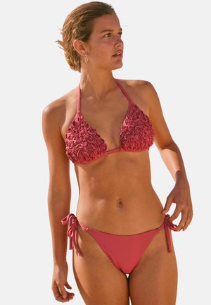 Korallin pinkki bikinit, joissa on teksturoitu kukkakuvio bralette-osassa ja sileä, tukeva kangas nauhakiinnitteisissä alaosissa.