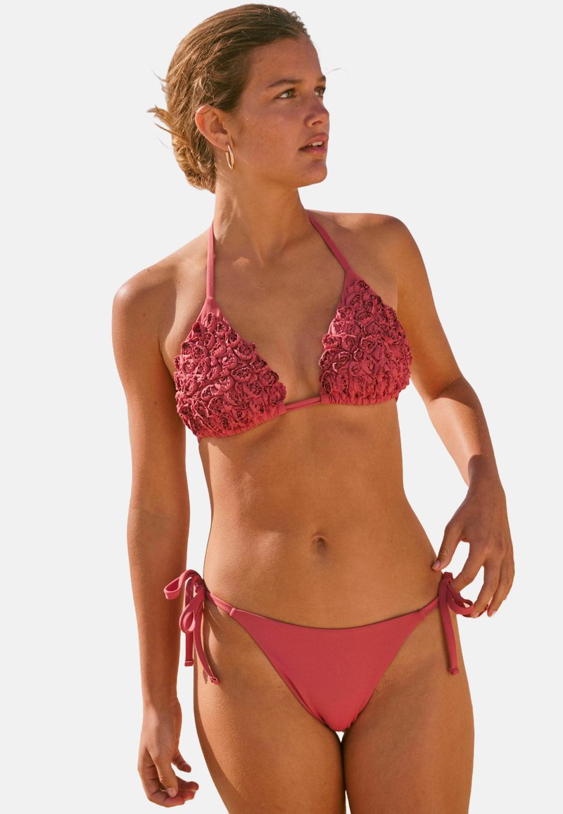 Koraalroze bikini met een textuur van bloemenontwerp op de bralette en een gladde effen stof op de zijbanden van de onderbroek.