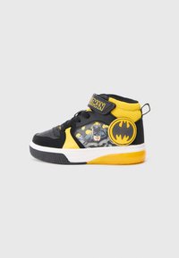 Sneakers alte black e gialle con grafica di Batman, fascia in Velcro e emblema rotondo con il logo di Batman sul lato.