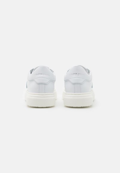 Baskets en cuir blanc avec une finition texturée, dotées d'une épaisse semelle blanche et d'accents bleu clair sur les côtés. Design minimaliste avec un embossage.