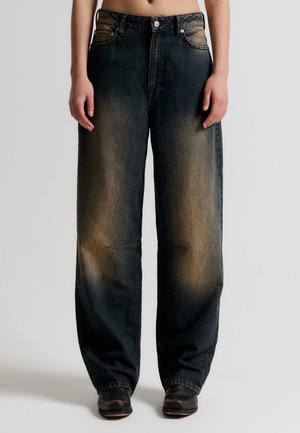 Donkerblauwe denim brede pijpenjeans met vervaagde lichtere plekken, vijf zakken, zichtbare stiksels en een metalen knoopsluiting.
