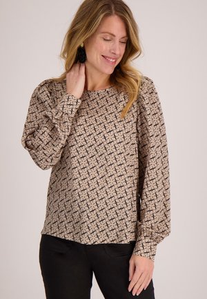 Beige blouse met patroon en lange pofmouwen, met een herhalend circulair ontwerp in het zwart. Zachte stof met een ronde halslijn en een losse pasvorm.