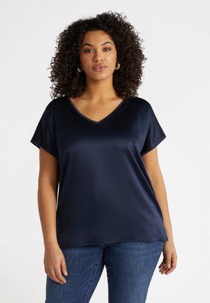 Blusa blu navy in satin con scollo a V, maniche corte e vestibilità rilassata, caratterizzata da una superficie liscia e cuciture minime per un aspetto elegante.