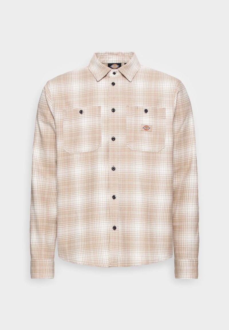 Chemise à carreaux beige et blanche à manches longues avec deux poches poitrine, boutons noirs et petit logo de la marque sur la poche gauche.