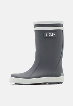 Bota de lluvia de goma gris oscuro con ribete blanco, etiqueta de la marca AIGLE en el lateral y suela blanca texturizada para mayor agarre.