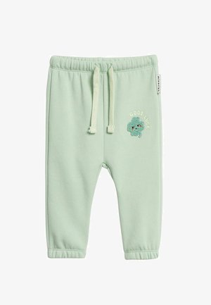 Lichtgroene peuterbroek met elastische taille, trekkoorden en geborduurde tekst "Good Luck" met een glimlachende klaver op het rechterbeen.