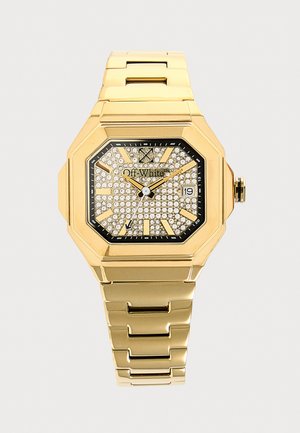 Montre en métal doré avec cadran octogonal, cadran serti de cristaux, index noirs, affichage de la date et bracelet à maillons.
