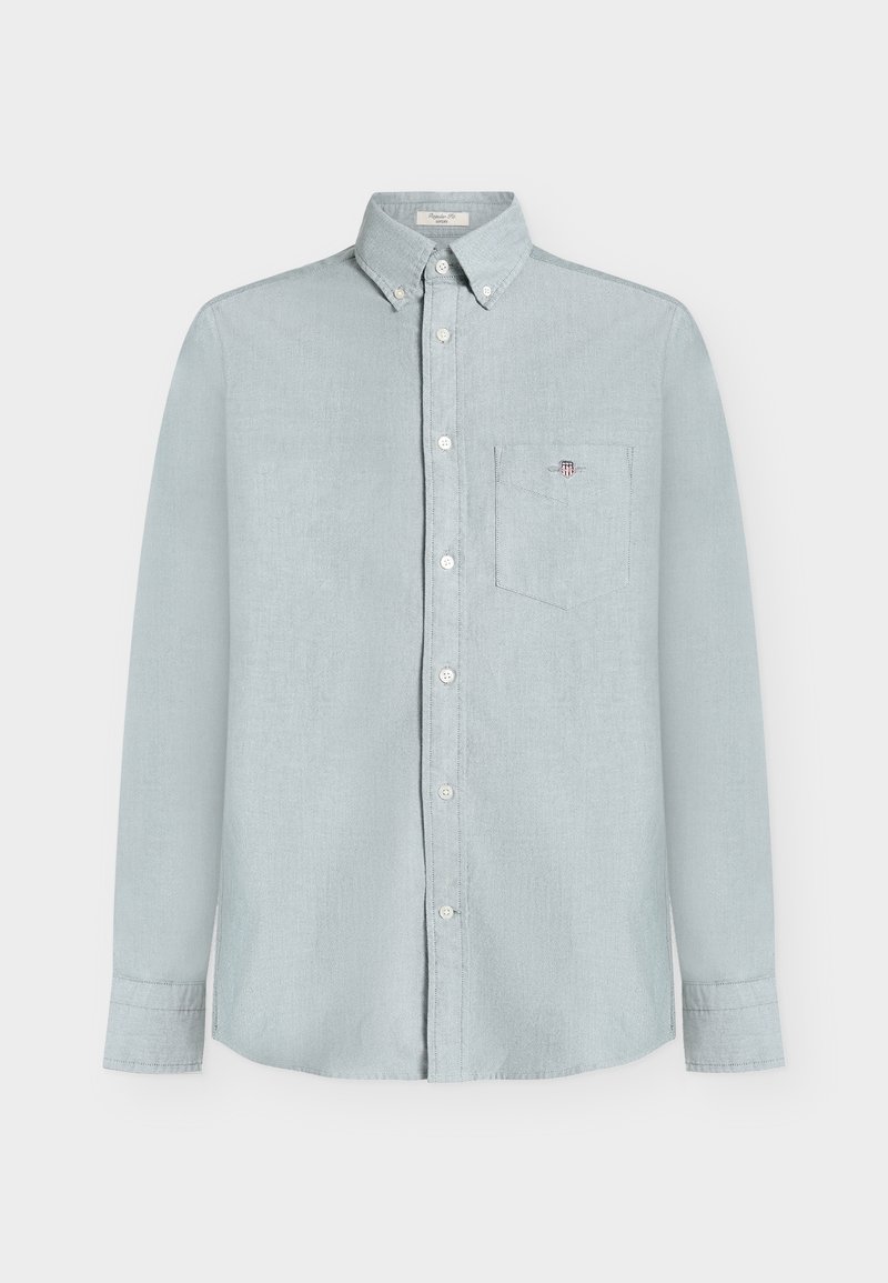 Camisa azul claro de manga larga con botones, cuello, bolsillo frontal en el pecho con pequeño logo bordado y botones blancos en la parte delantera.