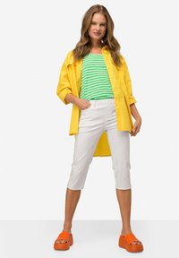 Geel button-up overhemd, groen en wit gestreept shirt, witte cropped broek en oranje platform sandalen. Gladde texturen en contrasterende kleuren.