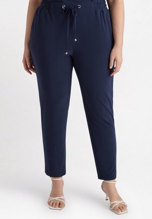 Pantaloni jogger blu navy realizzati in morbido tessuto, con vita regolabile con cordino, polsini elasticizzati e dettagli in metallo color argento.
