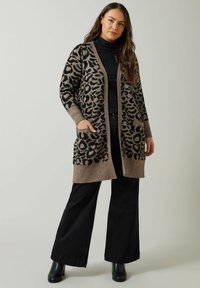 Beige ja musta leopardimustriga kardigan, pikad varrukad, avatud esi, kaks taskut, kudumise tekstuur, ühendatud mustade laia jala pükstega.