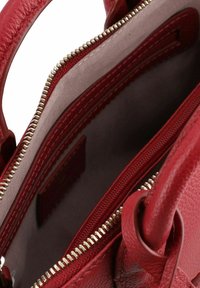 Borsa a mano in pelle rossa con texture, dotata di un interno morbido e foderato, con cerniere in metallo dorato e una tasca interna per l'organizzazione.