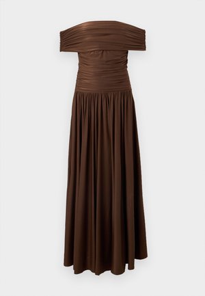 Robe longue marron à épaules dénudées avec corsage froncé et jupe fluide plissée sur un fond clair uni.