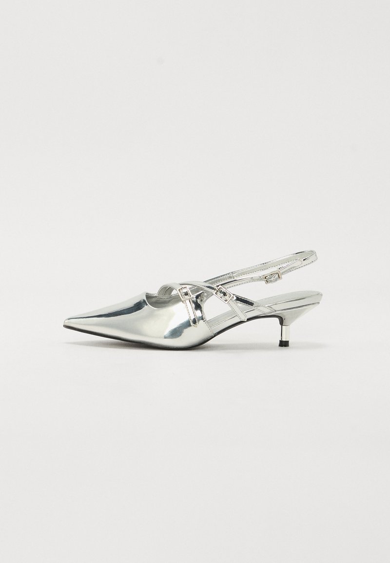 Chaussures argentées métalliques à dos ouvert avec un bout pointu, un petit talon kitten et des détails de sangle à l'avant. Surface lisse et brillante.