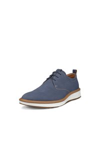 Scarpa blu in suede con lacci, suola testurizzata bianca e marrone, con cuciture a contrasto e una piccola linguetta sul tallone per facilitarne l'indossamento.