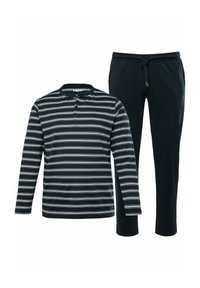 Camisa henley de manga larga a rayas en blanco y negro combinada con pantalones deportivos negros que cuentan con una cintura elástica y cordón ajustable.