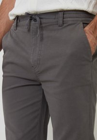 Grijze katoenen broek in een mix met een elastische tailleband, voorzakken en een gladde, gestructureerde afwerking. Voorzien van een trekkoord voor een verstelbare pasvorm.