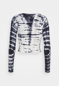 Długi rękaw, krótki top w nadruk tie-dye. Charakteryzuje się granatowo-białymi wirującymi wzorami, okrągłym dekoltem i miękkim, elastycznym materiałem.